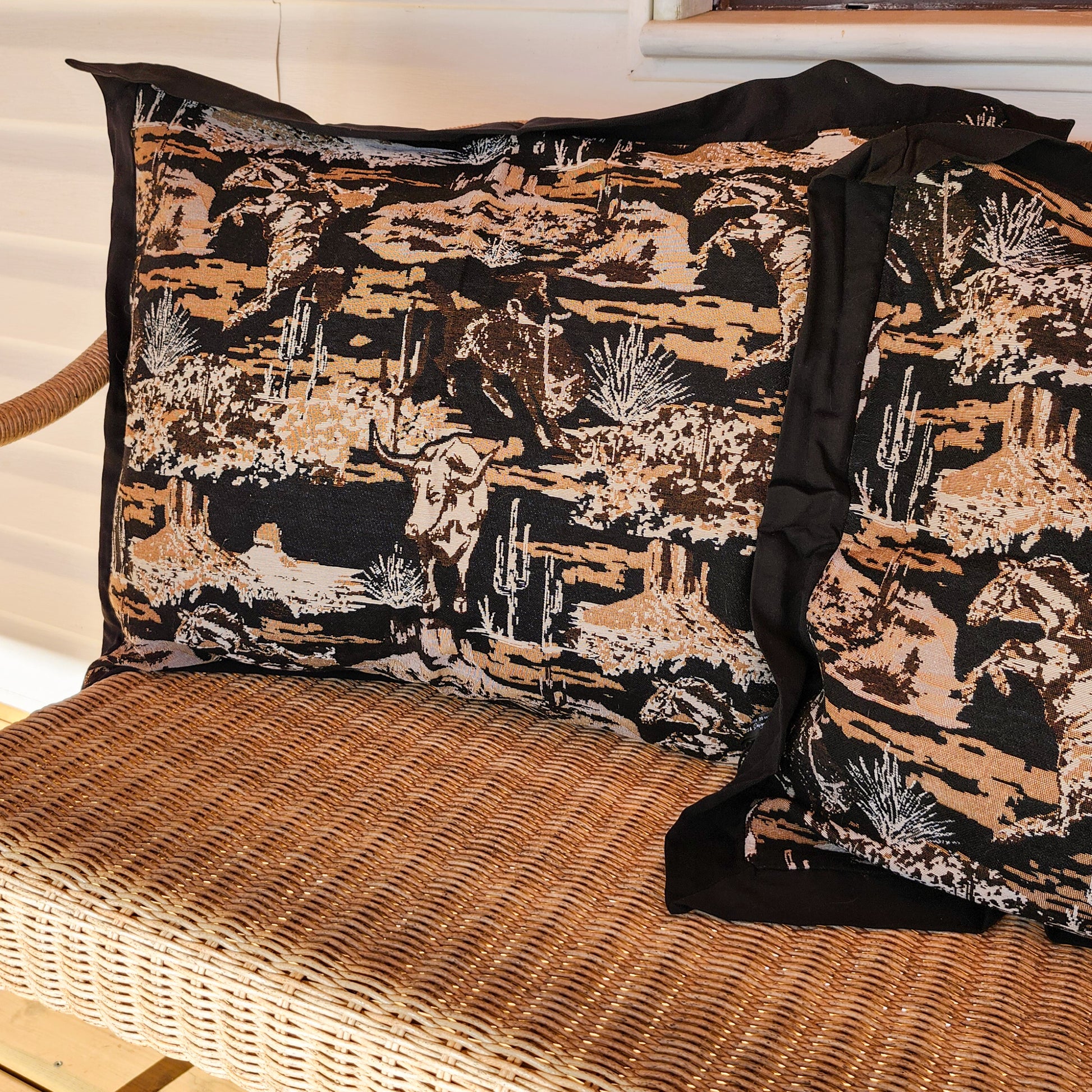Set of 2 western jacquard tapestry pillowcases on woven wicker bench, black and tan textured fabric with desert-inspired pattern