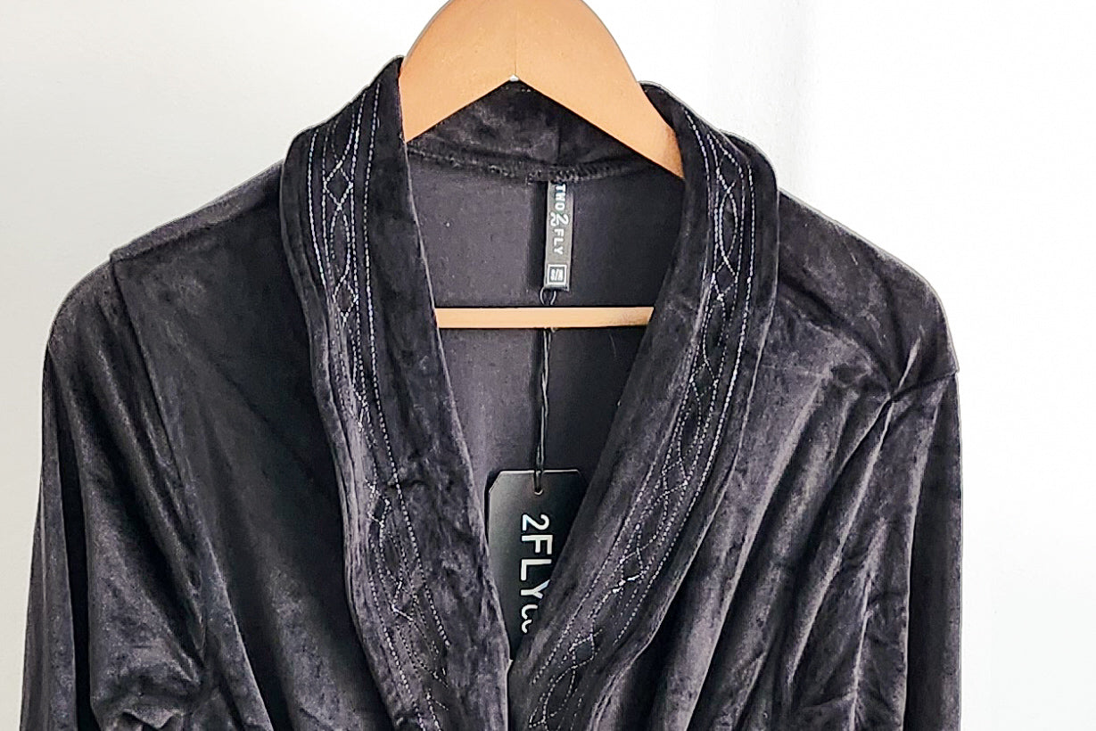 soft black velvet lounge robe with western detailing hanging on wooden hanger