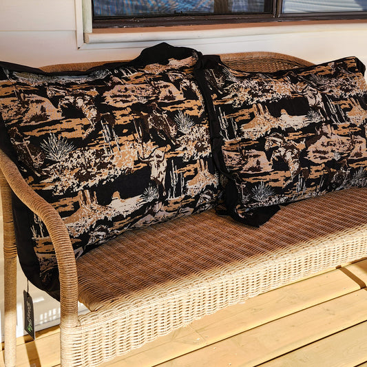 Set of 2 western jacquard tapestry pillowcases on woven wicker bench, black and tan textured fabric with desert-inspired pattern
